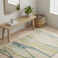 Room interior with a wooden bench, plant, and decorative items on a patterned rug.