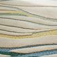 Close-up of a textured fabric with wavy lines in beige, green, and blue.