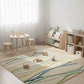 Children's playroom with a colorful rug, wooden furniture, and toys.