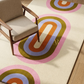 Colorful circular patterned rug with a chair on top