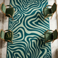 Patterned rug with wavy design in a room with chairs and a window.