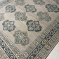 Close-up of a patterned rug with geometric designs on a neutral background
