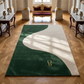 Luxurious green and white rug with a gold logo on a wooden floor in an elegant room.