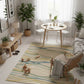 Modern living room with a round dining table, chairs, and a striped rug.