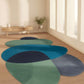 Three circular rugs in blue and green on a wooden floor with a minimalistic room background.