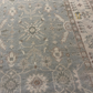 Close-up of a patterned rug with intricate designs on a neutral background