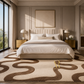 A luxury bedroom featuring a large beige and brown abstract patterned area rug on the floor, a tufted beige bed frame, gold nightstands, and a large window with a view of greenery outside.