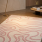 Rug with wavy pattern in a room with a lamp and table.