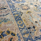 Close-up of a patterned rug with blue, beige, and brown colors.