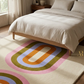 Bedroom with a colorful geometric rug and wooden bed frame.