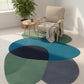 Multicolored rug on a light wooden floor with a chair and plant in the background.