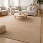 Living room with a beige rug, white sofa, and wooden coffee table.