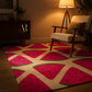 A watermelon-patterned area rug in a cozy living room setting next to a mid-century modern armchair and a lit floor lamp.