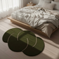 Green circular rugs on a light wooden floor in a bedroom setting.