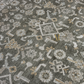 Close-up of a patterned fabric with geometric and floral designs on a dark background.