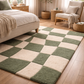 Checkered green and beige rug in a bedroom with a bed and chair.