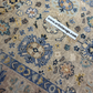 Close-up of a patterned rug with decorative elements and a visible brand label.