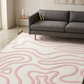 Living room with a gray sofa and a pink and white patterned rug.
