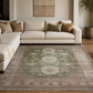 Living room with a beige sectional sofa and a patterned rug.