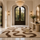 A large area rug with a wavy, organic brown pattern on a cream background, styled in a luxurious entryway with marble floors, a crystal chandelier, and dark wood double doors.