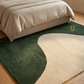 Two area rugs with a green and beige design on a wooden floor.