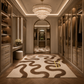 A luxury walk-in closet with a large patterned area rug on a herringbone wood floor, featuring built-in shelving, glass wardrobe doors, a crystal chandelier, and a vanity desk.