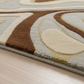 Close-up of a patterned rug with brown, beige, and gray colors on a wooden floor.