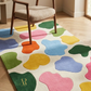 Colorful abstract rug with multicolored shapes on a wooden floor, featuring a chair.