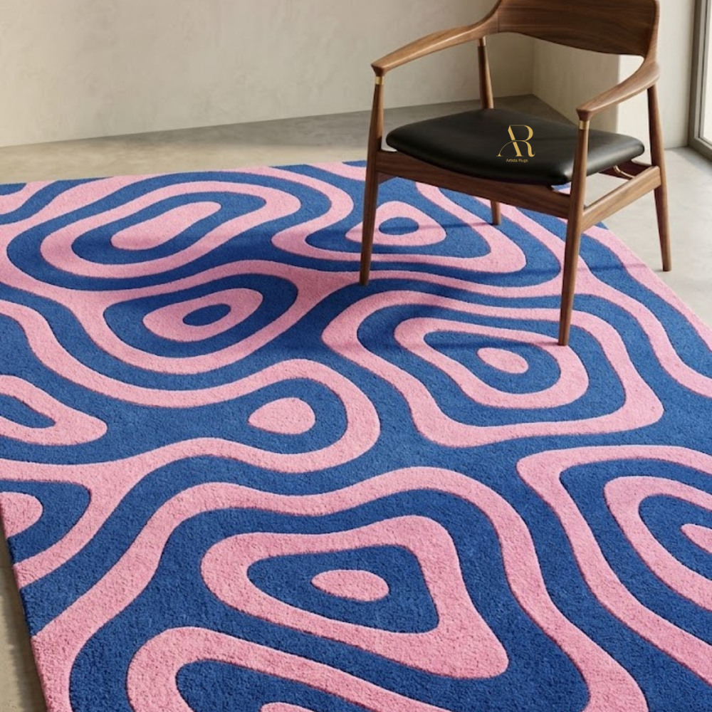 Pink and blue patterned rug with a wooden chair and black cushion.
