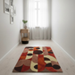 Colorful geometric-patterned rug on a light wooden floor with a side table and plant in the background.