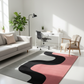 Modern living room with a colorful abstract rug, sofa, and office desk.