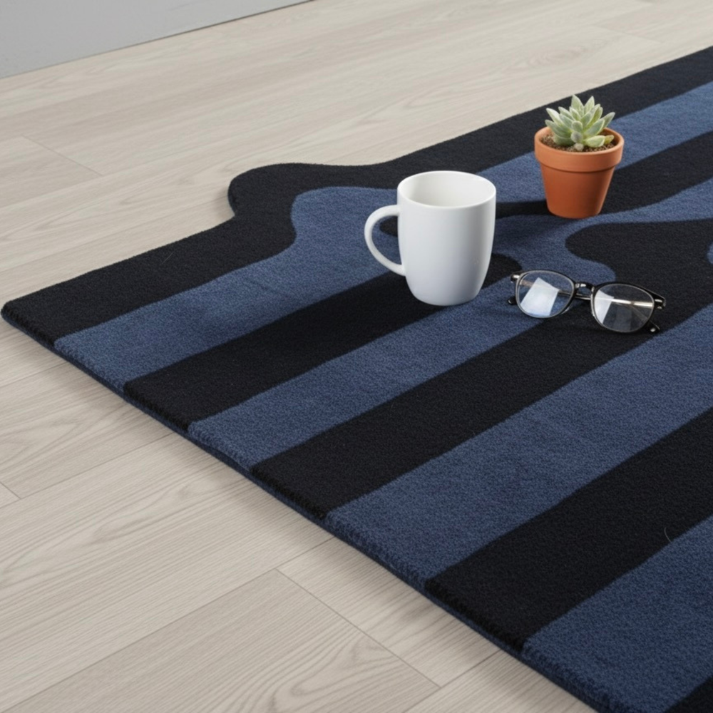 Blue and black striped rug with a white mug, sunglasses, and a small plant on a light wood floor.