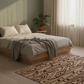 Neatly made bed with white bedding and a patterned throw blanket in a room with a plant and curtains.