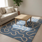Living room with a blue rug featuring white patterns, beige sofa, and wooden coffee table.