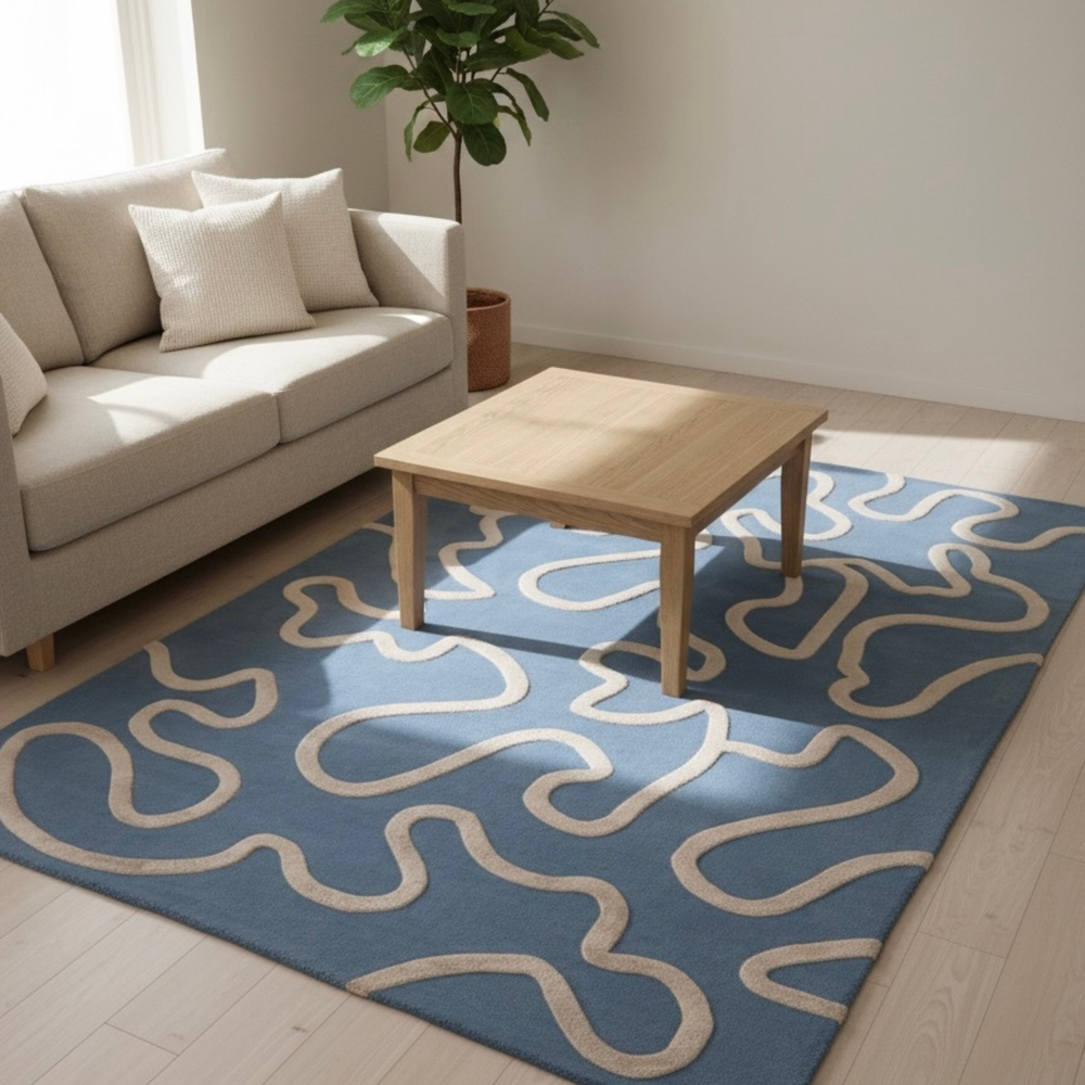 Living room with a blue rug featuring white patterns, beige sofa, and wooden coffee table.