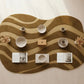 Wavy brown rug with white cups, a wooden box, and small decorative items on a light background
