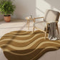 Wavy patterned rug in a room with a chair and plant