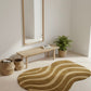 Wavy patterned rug on a light wooden floor with a mirror and plants in the background.