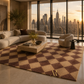 A large area rug with a brown and beige diamond pattern is styled in a luxury modern living room with a city skyline view at sunset.