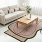 Living room with a beige sofa, wooden coffee table, and a pink and green rug.