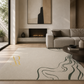 A large cream-colored area rug with abstract dark green wavy lines and a gold 'AR' monogram logo in the bottom-left corner, styled in a modern living room setting.