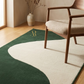 Green and white rug with a chair and vase in a room