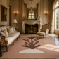 A large blush pink area rug with a dark brown coral-like abstract motif and a white semicircle at the bottom, styled in a luxurious, warm-toned classic living room with gold furniture and a fireplace.
