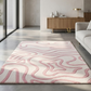 Modern living room with a pink and white patterned rug, gray sofa, and wooden sideboard.
