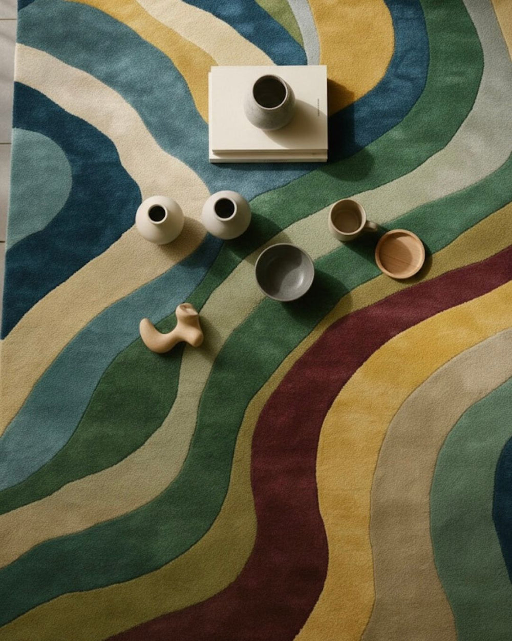 Colorful abstract rug with wavy patterns and ceramic items on top