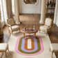 Colorful oval rug in a stylish room with chairs and a table.