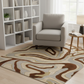 Gray armchair in a living room with a patterned rug and bookshelf.