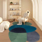 Modern room with a colorful rug on the floor and a chair with a blanket.