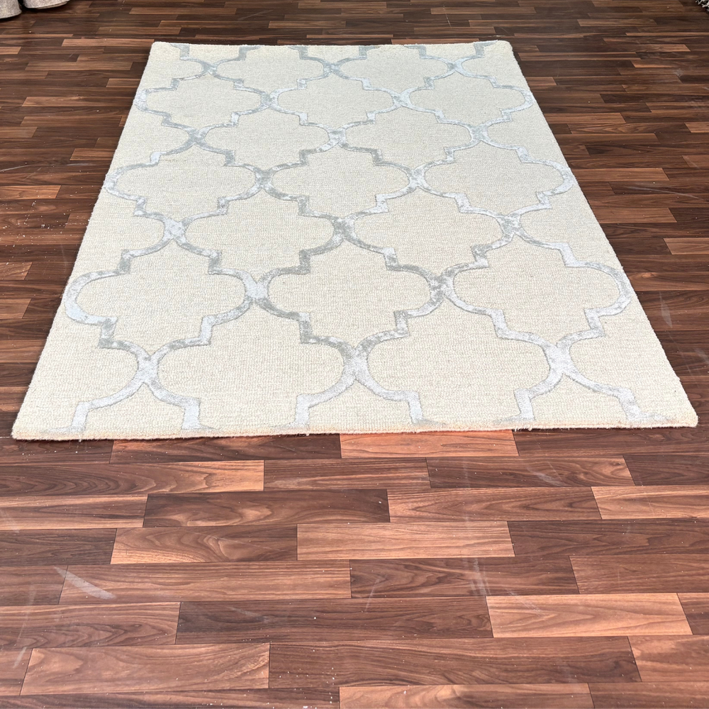 Beige patterned rug on a wooden floor