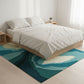 Bedroom with a bed and a colorful rug on a wooden floor.